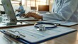 © Muhammad - Stethoscope on prescription clipboard and Doctor working an Laptop on desk in hospital
