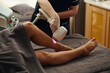 © DragonImages - Beautician removing hair from legs of young woman with laser