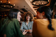 © La Famiglia - Four female friends having a great time in cafe, sitting, and about to order drinks and food