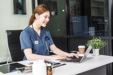 A young Asian nurse providing online consultations, seated at her desk with a laptop. She offers medical advice and support remotely, leveraging technology to assist patients efficiently.