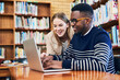 © NonVig/peopleimages.com - Student, woman and laptop in library for research, studying and exam preparation on campus. Team, education and technology with smile for knowledge, social media and learning on internet with help
