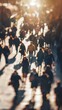 © kanoktuch - Blurry Crowd In Sunlight showcasing people walking in a busy street, illuminated by warm sunlight.