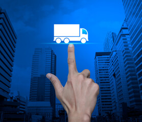 Poster - Hand pressing truck flat icon over modern city tower and skyscraper, Truck transportation service concept