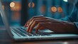 © Parintron - Close-up of a person typing on a laptop keyboard. The person is wearing a blue shirt and has their hands on the keyboard. The background is blurry and has a blue tint.