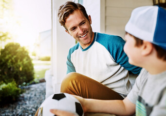 Happy, kid and dad with soccer ball by home for outdoor sports, bonding and conversation on weekend. Smile, man and son outside house with love for exercise, practice and break on fathers day