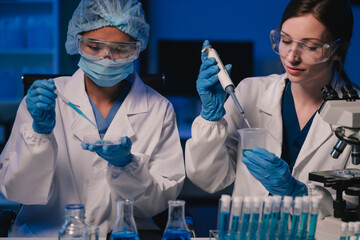 Wall Mural - team of biochemical research scientists working with a microscope for vaccine development in pharmac