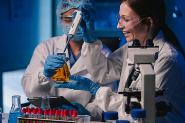 Wall Mural - team of biochemical research scientists working with a microscope for vaccine development in pharmac