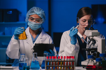 Wall Mural - team of biochemical research scientists working with a microscope for vaccine development in pharmac