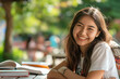 © Ruwinda - smilling student in the park and books on the table