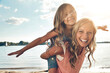 © peopleimages.com - Portrait, mother and child on beach with piggyback, smile and playing on adventure holiday in Australia. Travel, mom and girl with summer fun, happy and bonding together with airplane games outdoor.