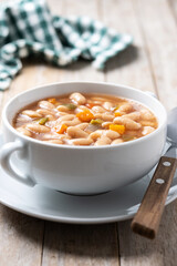 Wall Mural - White beans soup with vegetables in white bowl on wooden table