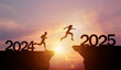 © Midnight Studio - New Year 2025, Inspiration and progress towards new success. Silhouettes of human jumping over cliff towards finish line with text new year 2025 on sunset beautiful