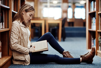 Poster - College student, library and girl reading book for education, studying and literature in English or language. Person relax on floor by shelf with novel, knowledge and scholarship for learning history