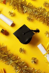 Wall Mural - A graduation cap and diplomas on a yellow background, perfect for educational or achievement-themed designs