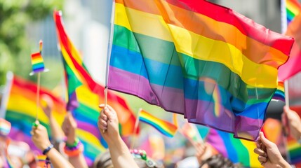 Crowd celebrating with rainbow flags at a public event