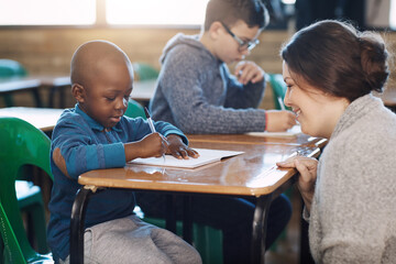 Poster - Happy teacher, woman and help kid writing in notebook for education, studying or knowledge in class. Child, educator and student learning in lesson for development or support at kindergarten school