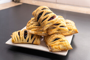 Wall Mural - Puff pastry dough with blueberries on a black background. dessert. food concept diet