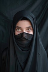 Wall Mural - A woman wearing a black veil that covers her face and identity