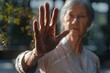 © Fotograf - An elderly person holds their hands up in a gesture of joy or prayer
