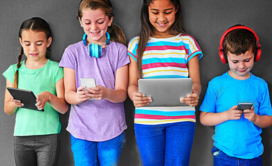 Poster - Studio background, technology and group of children for education, elearning and online research with smile. Happy students, girls and boy with digital app of tablet, smartphone and headphones