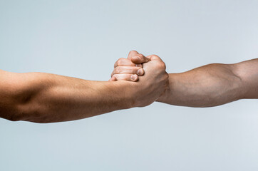 Wall Mural - Handshake, arms, friendship. Friendly handshake, friends greeting, teamwork friendship. Rescue, helping gesture or hands. Strong hold. Close-up. Two hands, helping hand of a friend