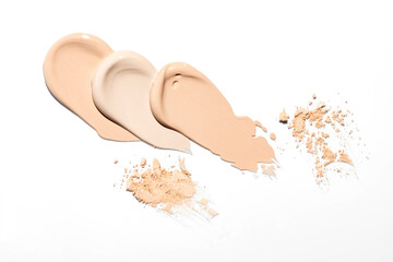 Wall Mural - Samples of light beige skin tone cosmetics, arranged on white surface with smears of liquid concealer, piles of powder compact, isolated on white, viewed from above