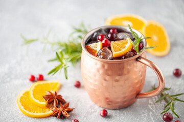 Wall Mural - Cranberry Orange Moscow mule, holiday drink in a copper mug. Grey stone background.