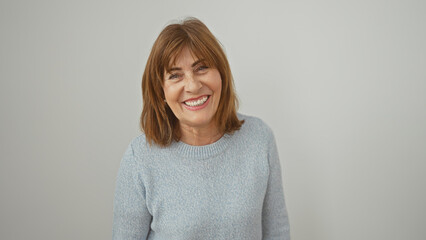 A smiling mature woman with short hair wearing a sweater against a white background.