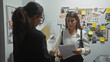 © Krakenimages.com - Two women reviewing investigative documents in a detective's office, with a corkboard of evidence in the background.