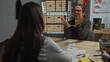 © Krakenimages.com - A woman in handcuffs explains herself to an interrogator in a police department laden with evidence, including passports.