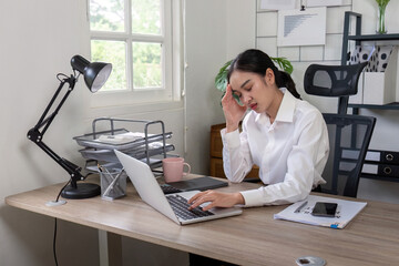 Wall Mural - Stress Businesswoman Experiencing Headache at Work Desk with Laptop and Documents in Modern Office Setting