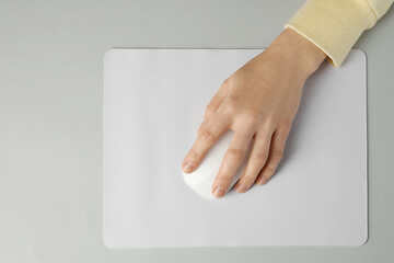 Wall Mural - Woman using modern wireless computer mouse on grey background, top view