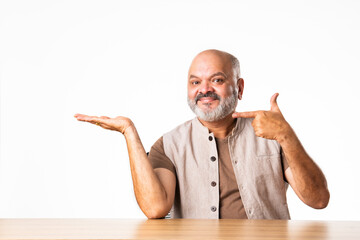 Wall Mural - Expressive Indian asian old retired senior man sitting at table