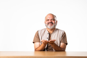 Wall Mural - Expressive Indian asian old retired senior man sitting at table