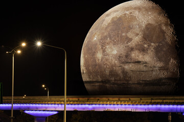 Wall Mural - The supermoon rises above the horizon. Photo collage of a huge moon over a road bridge with street lights at night