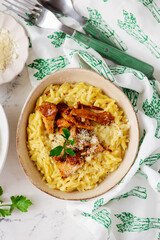 Wall Mural - Orzotto with chanterelles, Parmesan cheese and parsley in a deep ceramic bowl.