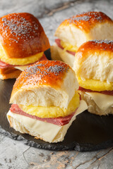 Wall Mural - Ham and cheese sliders with a tropical twist a slice of pineapple closeup on the slate board on the table. Vertical