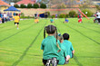 © Nico - A primary school faction colour relay race. Kids photographed from behind looking down the running track