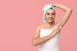 © Pixel-Shot - Young woman with roll-on deodorant on pink background