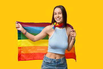 Canvas Print - Beautiful young happy woman with piercing navel and LGBT flag on yellow background