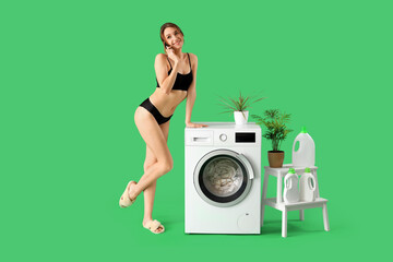 Wall Mural - Attractive young woman in underwear talking by mobile phone while doing laundry on green background