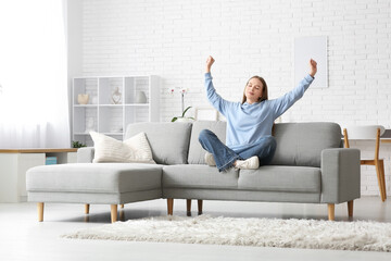 Sticker - Young tired woman resting on sofa in stylish living room