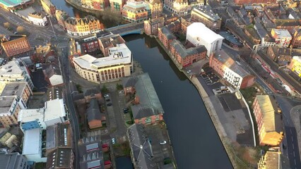 Wall Mural - Aerial drone footage of the town centre of Leeds in West Yorkshire UK, showing the whole of the Leeds City Centre and the glass building of the Trinity centre, taken at sunrise with the sun reflecting
