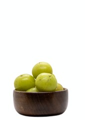 Wall Mural - Indian Gooseberry Fruit or Amla Fruit in a White Bowl Isolated on White Background with Copy Space, Also Known as Emblica Myrobalan or Phyllanthus Emblica in Vertical Orientation