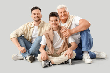 Sticker - Teenage boy with his dad and grandfather sitting on light background