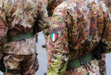 Italian army soldier in green and brown camouflage uniform with the flag of ITaly patch on arm