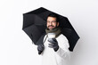 © luismolinero - Caucasian handsome man with beard holding an umbrella and a coffee to take away over isolated white wall