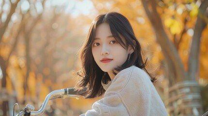 Wall Mural - A cute Korean girl, with gradient lips and light foundation, riding a bicycle in a park during autumn, showcasing her natural beauty and cute aesthetic. 