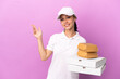 © luismolinero - Pizza delivery Russian girl with work uniform picking up pizza boxes and burgers isolated on purple background extending hands to the side for inviting to come