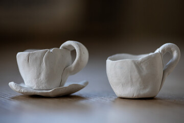 Close-up on two small coffee cups made of clay. Homemade clay objects.